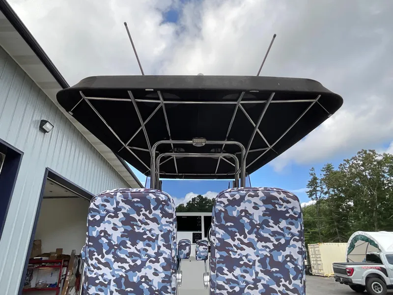Slide: The Image of 2019 Protector 310 Chase boat with camo seats and canopy, parked outdoors. - 34