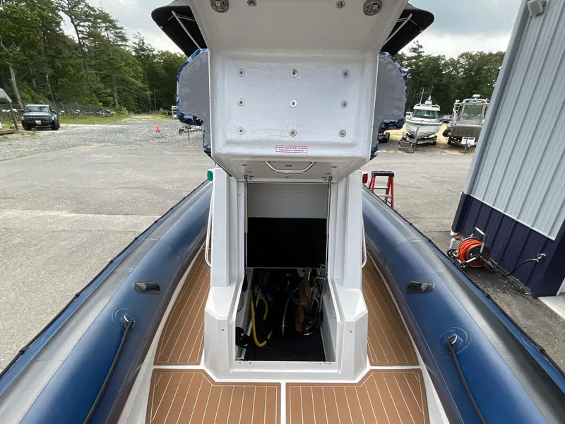 Slide: The Image of 2019 Protector 310 Chase boat with open storage compartment, docked outdoors. - 9