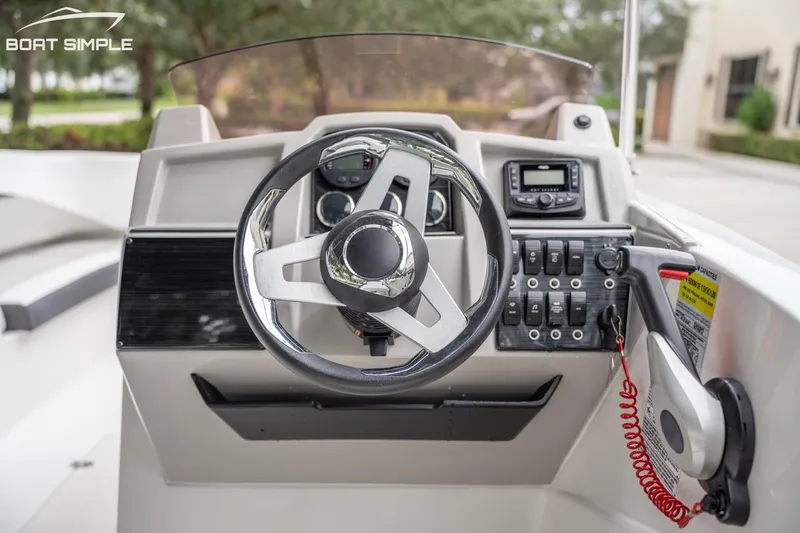 Slide: The Image of 2025 Starcraft SVX 231 OB DH boat dashboard with steering wheel and control panel. - 13