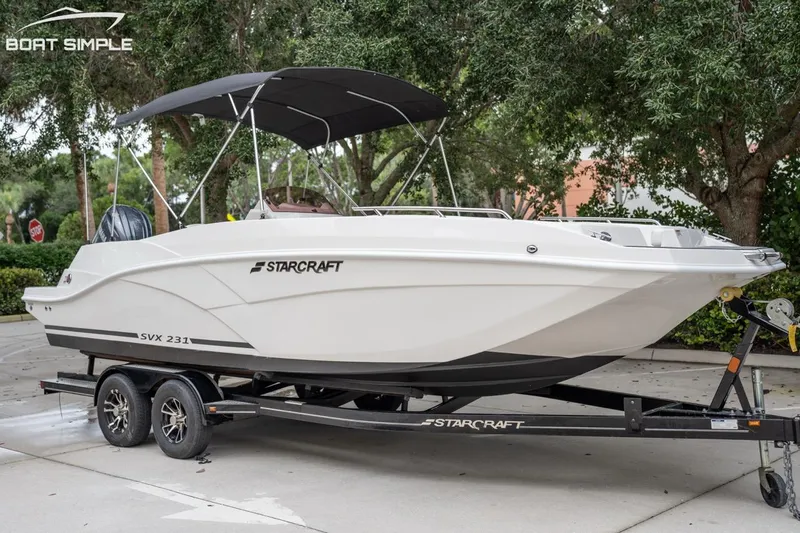 Slide: The Image of 2025 Starcraft SVX 231 OB DH boat on trailer, parked outdoors. - 5