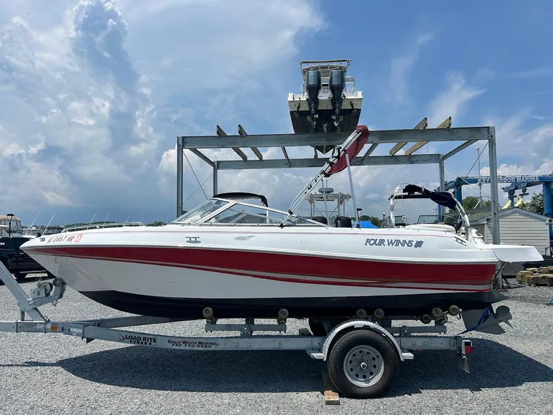 The Image of 2004 Four Winns 200 Horizon boat on trailer under cloudy sky. - 0