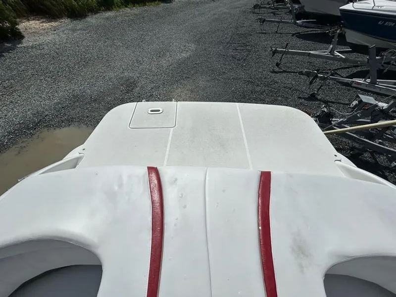Slide: The Image of 2004 Four Winns 200 Horizon boat on gravel, featuring white and red detailing. - 11