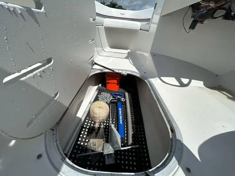 Slide: The Image of Storage compartment of a 2004 Four Winns 200 Horizon boat with various equipment. - 14