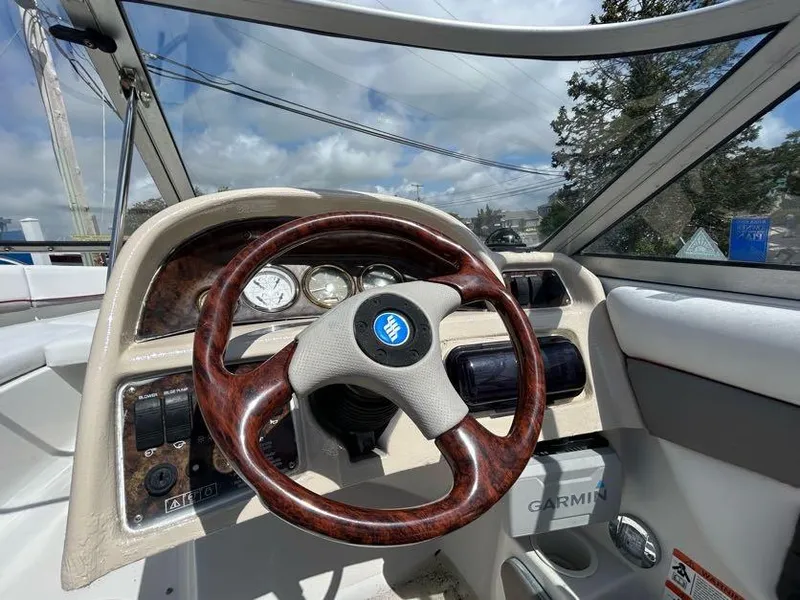 Slide: The Image of 2004 Four Winns 200 Horizon boat dashboard with wood-grain steering wheel and Garmin device. - 15