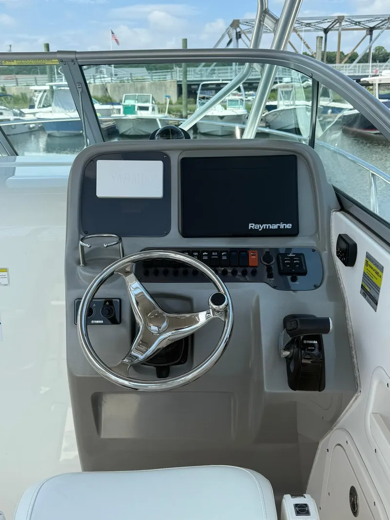 Slide: The Image of 2014 Robalo R245 Walkaround helm with Raymarine display and steering wheel. - 11