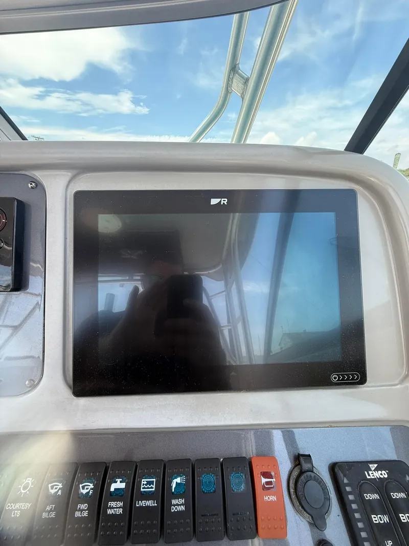 Slide: The Image of Control panel of a 2014 Robalo R245 Walkaround boat with touchscreen and switches. - 16