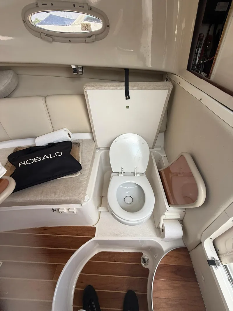 Slide: The Image of 2014 Robalo R245 Walkaround cabin with toilet and seating area. - 17