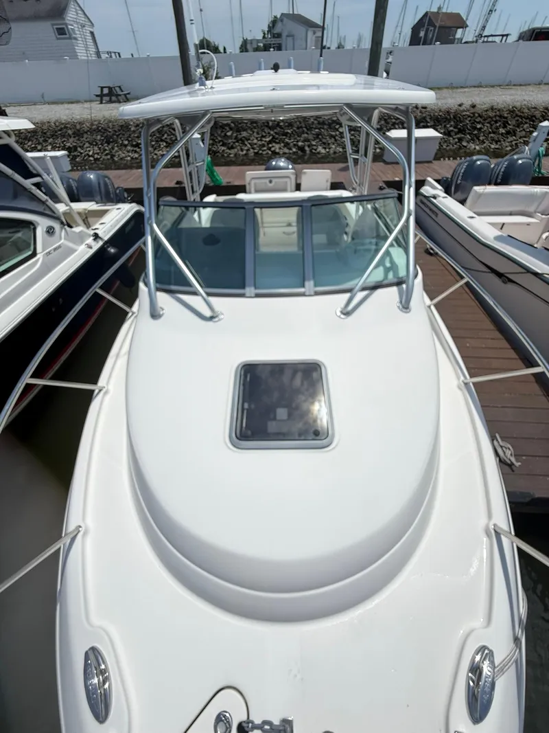 Slide: The Image of 2014 Robalo R245 Walkaround boat docked, top view showing cabin and deck. - 18