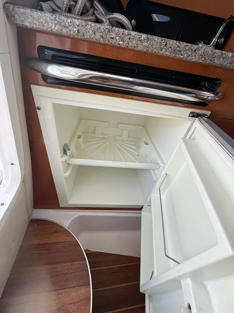 Slide: The Image of 2014 Robalo R245 Walkaround interior with open storage compartment and countertop. - 6