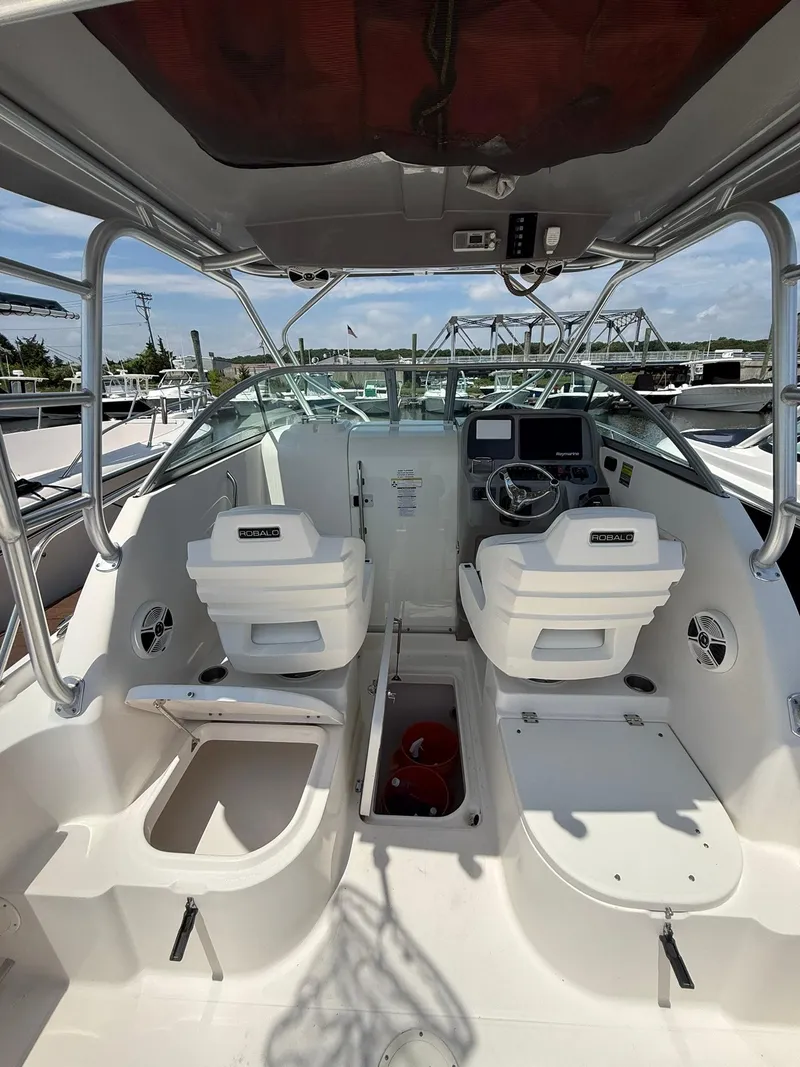 Slide: The Image of 2014 Robalo R245 Walkaround boat interior with helm, seating, and storage compartments. - 9