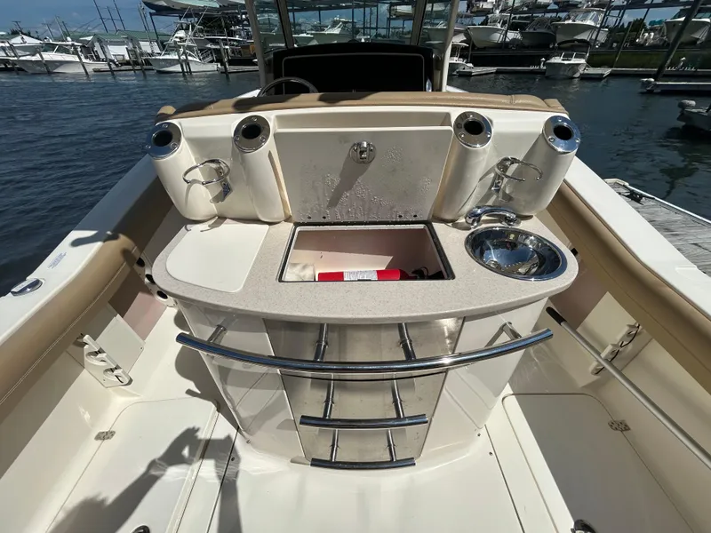 Slide: The Image of 2018 Scout 275 LXF boat interior with sink and storage at marina. - 10