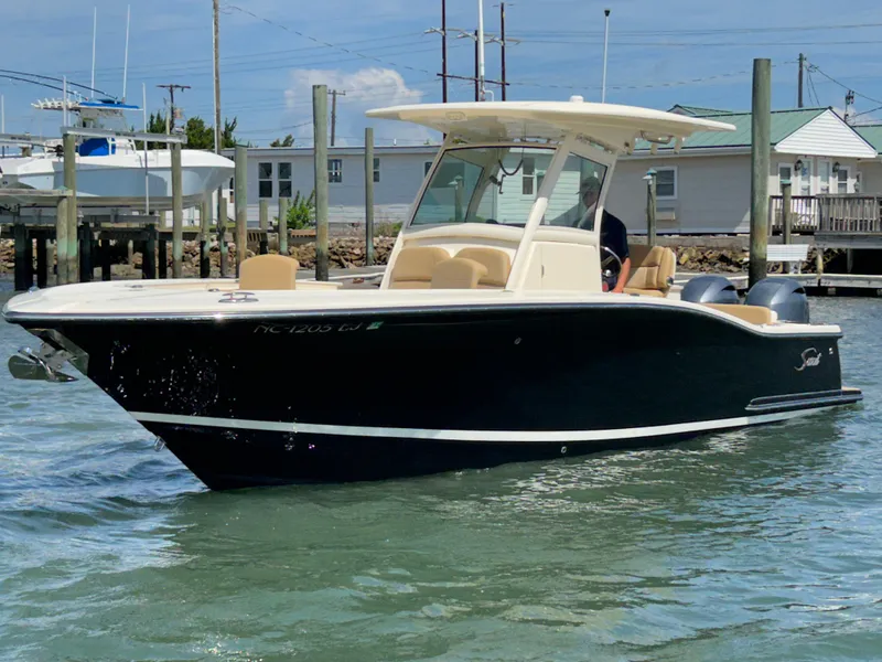 Slide: The Image of 2018 Scout 275 LXF boat on water, featuring sleek design and modern amenities. - 2