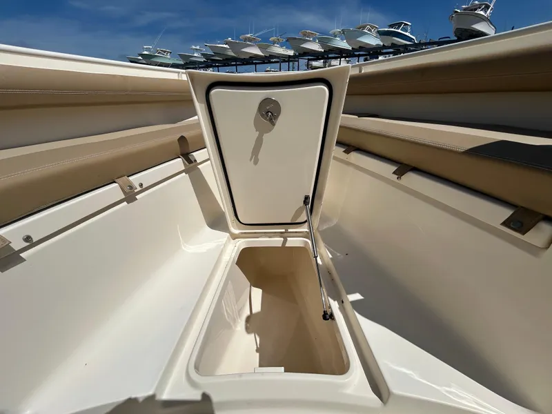 Slide: The Image of 2018 Scout 275 LXF boat storage compartment open under clear blue sky. - 22