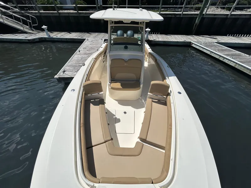 Slide: The Image of 2018 Scout 275 LXF boat docked, featuring spacious seating and sleek design. - 26