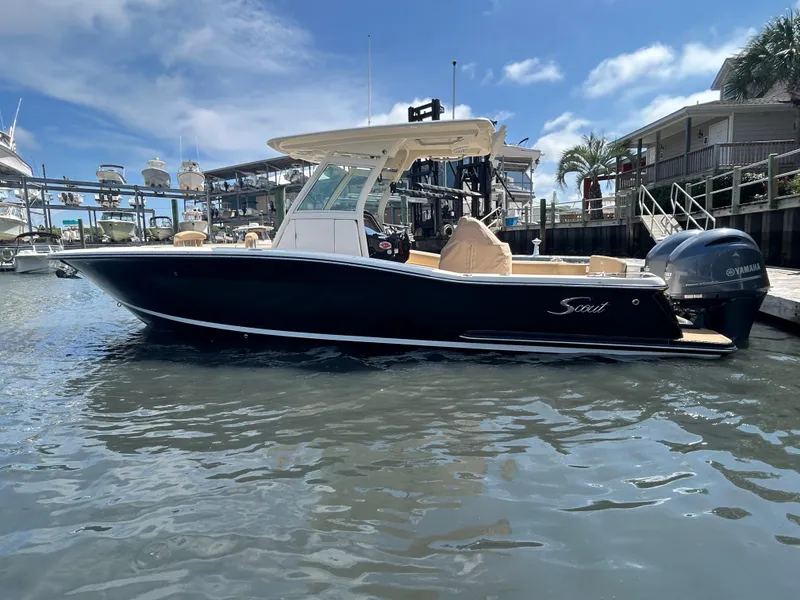 Slide: The Image of 2018 Scout 275 LXF boat docked at marina under clear blue sky. - 3