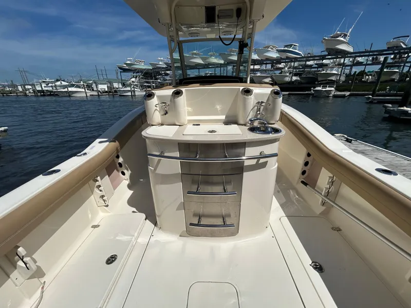 Slide: The Image of 2018 Scout 275 LXF boat interior with sink and storage, docked at marina. - 9