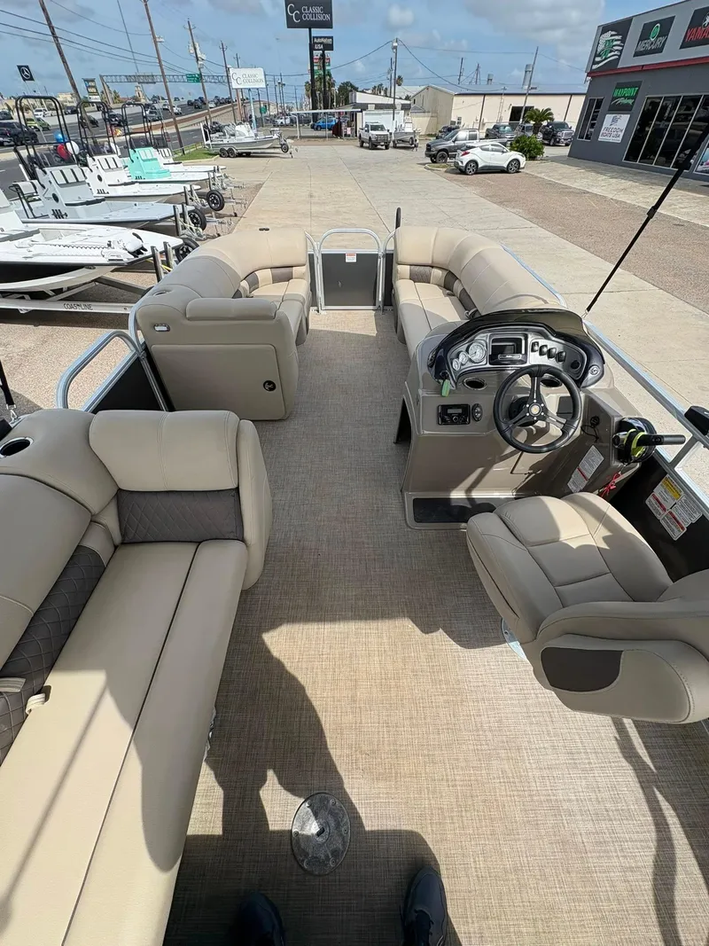 Slide: The Image of 2023 Sun Tracker Party Barge 20 DLX interior with beige seating and steering console. - 12