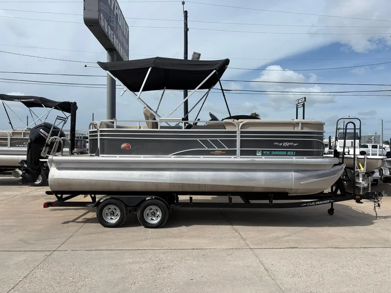 Slide: The Image of 2023 Sun Tracker Party Barge 20 DLX pontoon boat on trailer, parked outdoors. - 3
