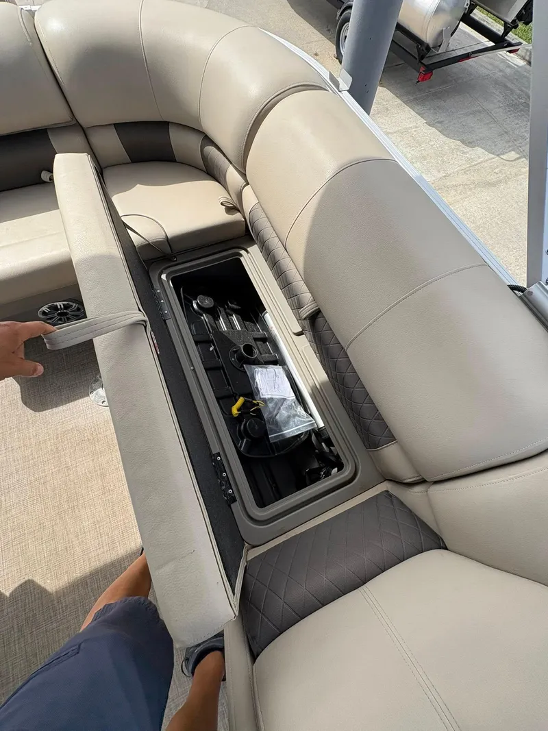 Slide: The Image of 2023 Sun Tracker Party Barge 20 DLX with open storage compartment under cushioned seating. - 8