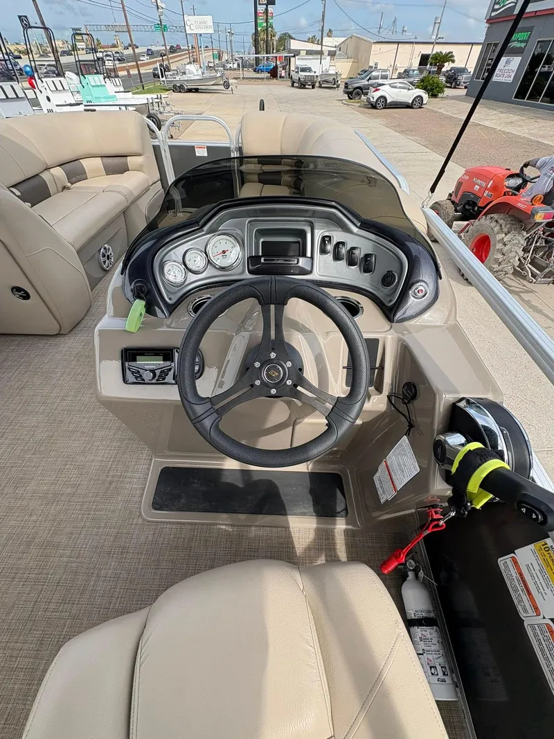 Slide: The Image of 2023 Sun Tracker Party Barge 20 DLX dashboard with steering wheel and controls. - 9