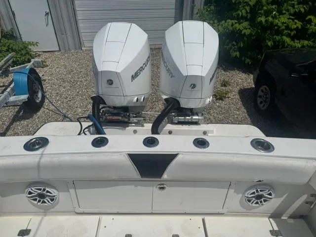 Slide: The Image of 1999 SeaVee 260B boat with dual Mercury outboard engines, docked on gravel. - 10