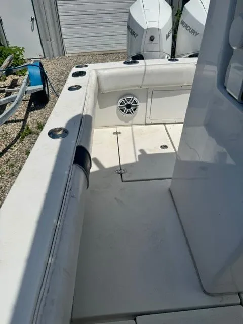 Slide: The Image of 1999 SeaVee 260B boat interior with Mercury engines, featuring rod holders and a speaker. - 20