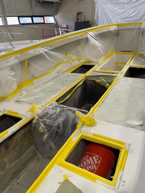 Slide: The Image of 1999 SeaVee 260B boat under renovation, interior view with yellow tape and plastic coverings. - 22