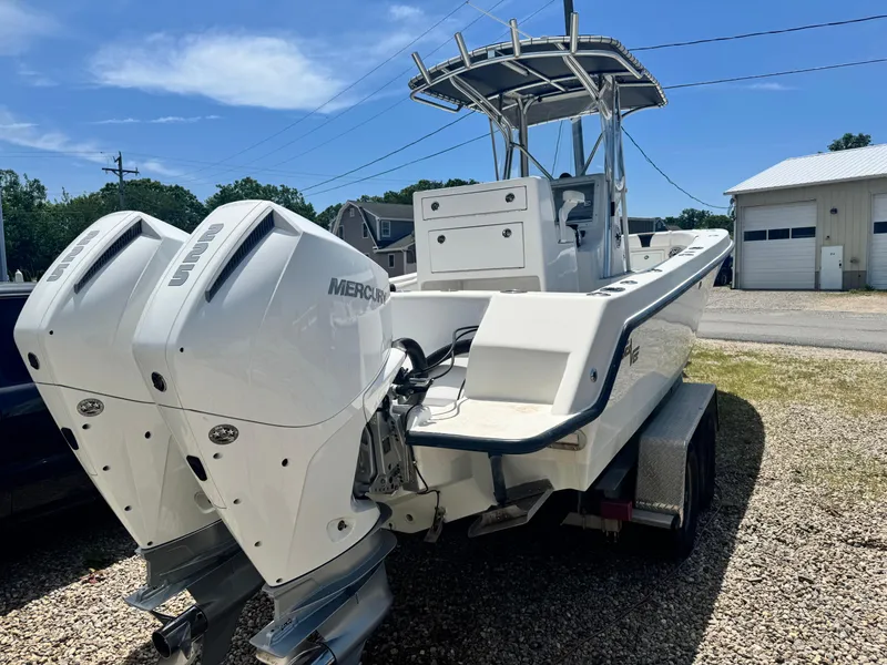 Slide: The Image of 1999 SeaVee 260B boat with dual Mercury engines on a trailer, parked outdoors. - 5