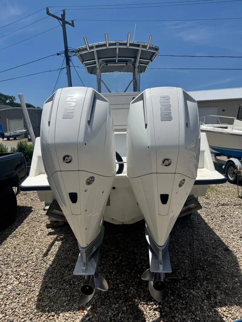 Slide: The Image of 1999 SeaVee 260B boat with dual outboard engines, parked on gravel. - 6