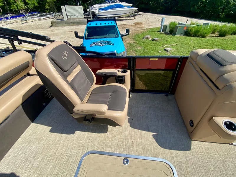 Slide: The Image of 2022 Barletta C24UC pontoon boat interior with beige seating and cup holders. - 12