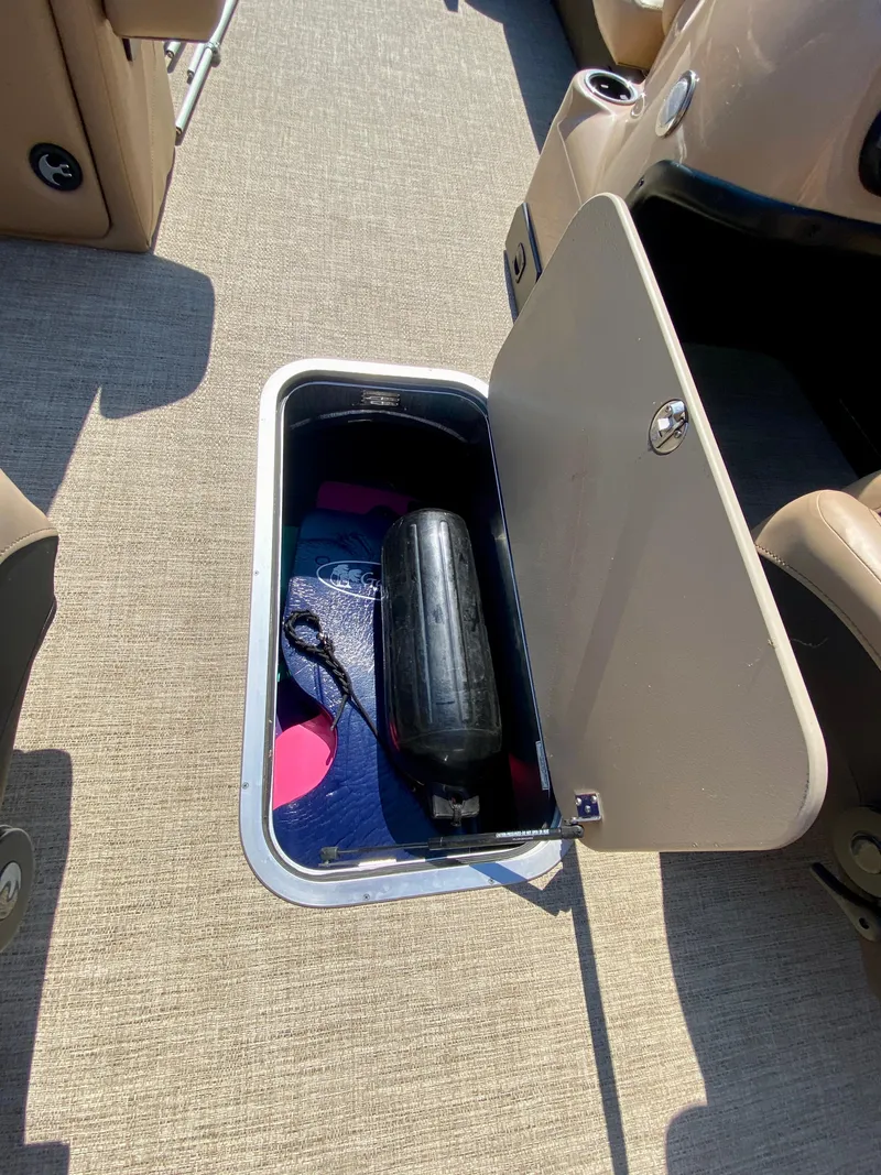 Slide: The Image of 2022 Barletta C24UC boat storage compartment with fender and colorful items inside. - 13