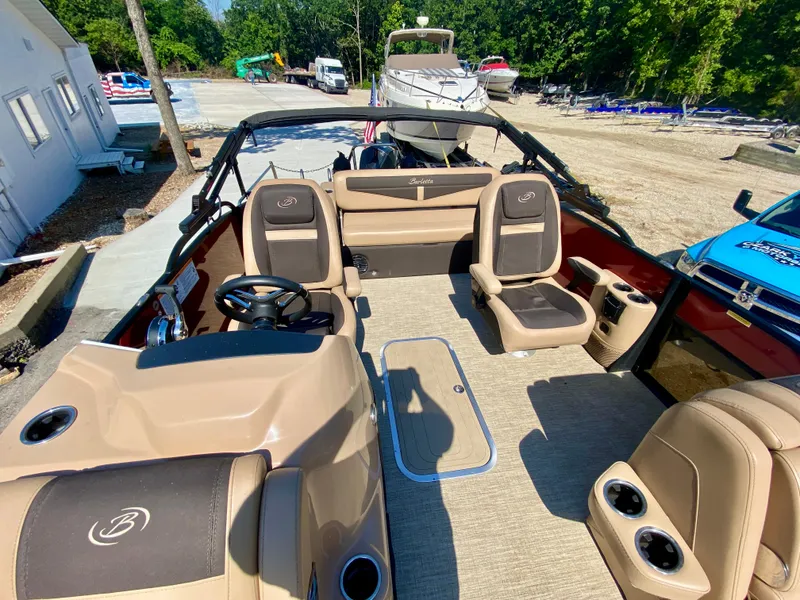Slide: The Image of 2022 Barletta C24UC boat interior with beige seating and steering wheel. - 14