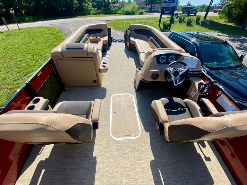 Slide: The Image of 2022 Barletta C24UC pontoon boat interior with beige seating and steering console. - 5