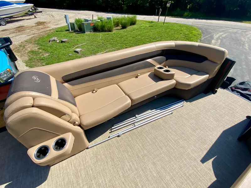 Slide: The Image of 2022 Barletta C24UC pontoon boat interior with tan seating and cup holders. - 7