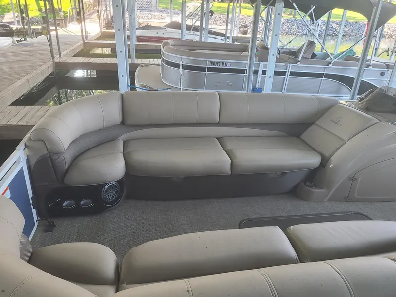 Slide: The Image of 2018 Regency 254 LE3 pontoon boat interior with beige seating and speaker system. - 2