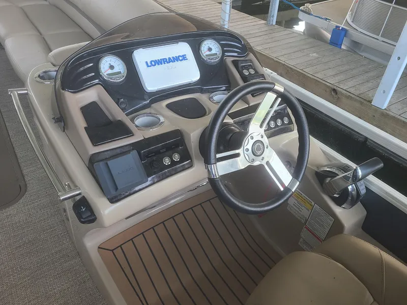 Slide: The Image of 2018 Regency 254 LE3 boat dashboard with steering wheel and Lowrance display. - 4
