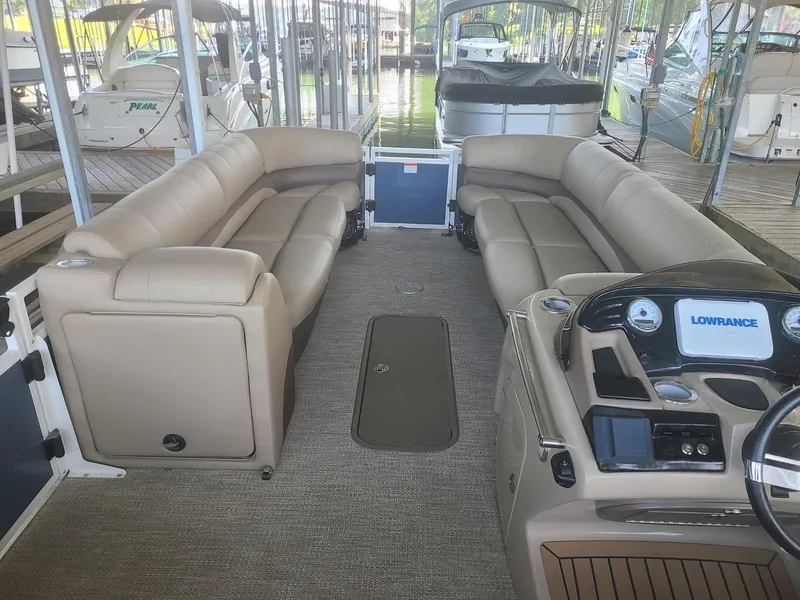 Slide: The Image of 2018 Regency 254 LE3 pontoon boat interior with beige seating and navigation console. - 5