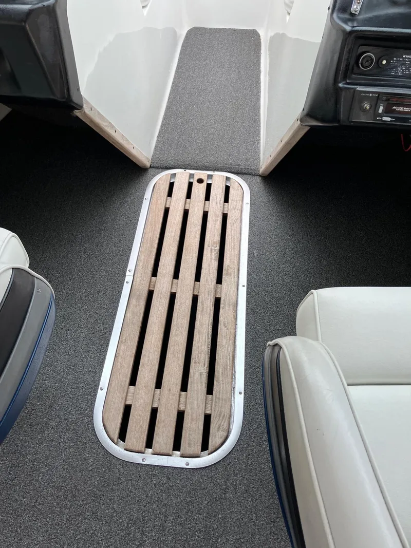 Slide: The Image of 1989 Rinker 206 Open Bow boat interior with wooden floor panel and cushioned seats. - 12
