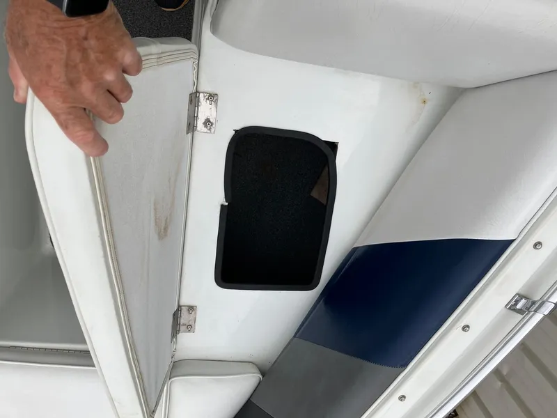 Slide: The Image of 1989 Rinker 206 Open Bow boat storage compartment with white and blue seating. - 16