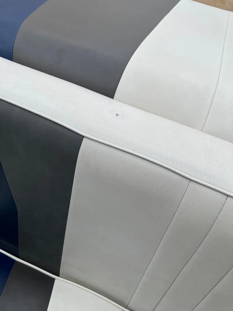 Slide: The Image of Striped upholstery on 1989 Rinker 206 Open Bow boat seat, featuring gray, white, and blue colors. - 21