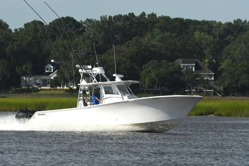 Slide: The Image of 2022 Front Runner 39 Center Console boat cruising on a scenic waterway. - 10