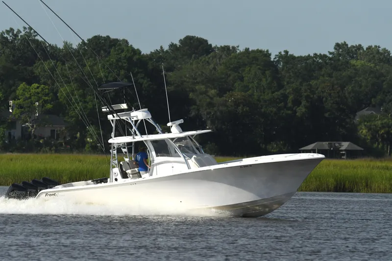 Slide: The Image of 2022 Front Runner 39 Center Console boat cruising on a calm river with lush greenery. - 12