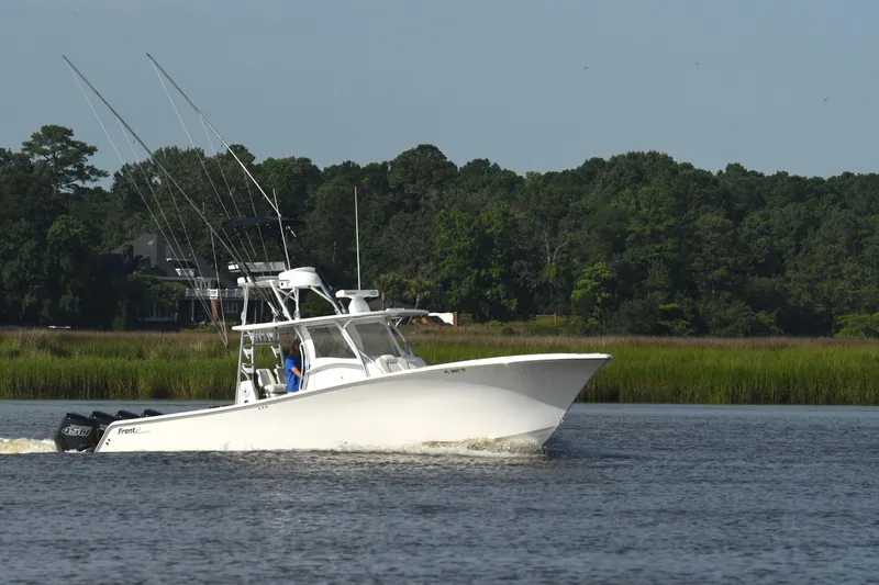 Slide: The Image of 2022 Front Runner 39 Center Console boat cruising on a calm river with lush green background. - 13