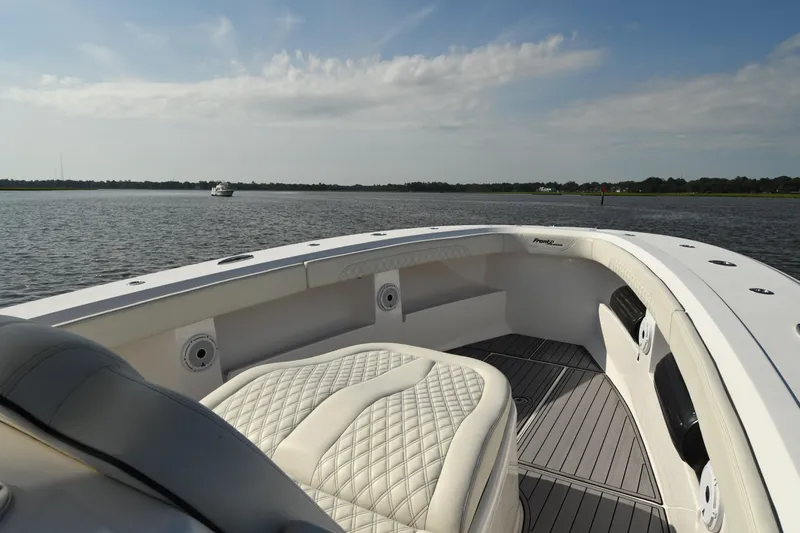 Slide: The Image of 2022 Front Runner 39 Center Console boat interior with luxurious seating on calm water. - 16