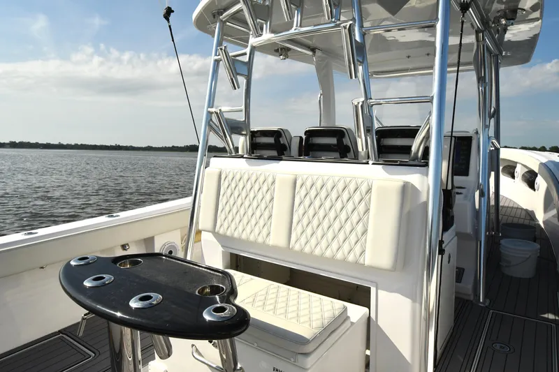 Slide: The Image of 2022 Front Runner 39 Center Console boat interior with seating and rod holders on a sunny day. - 17