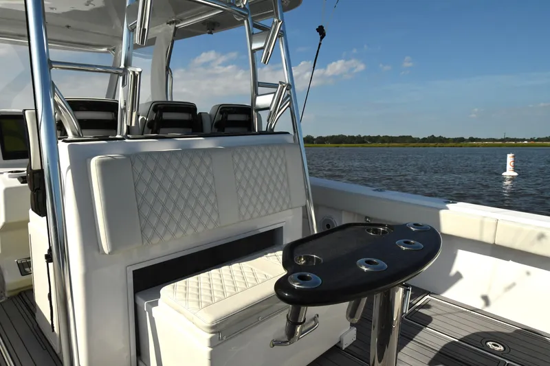 Slide: The Image of 2022 Front Runner 39 Center Console boat interior with seating and rod holders on a sunny day. - 21