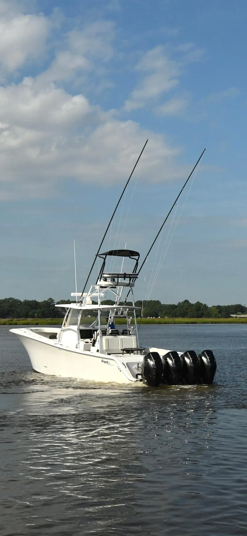 Slide: The Image of 2022 Front Runner 39 Center Console boat with four engines on a calm lake. - 5