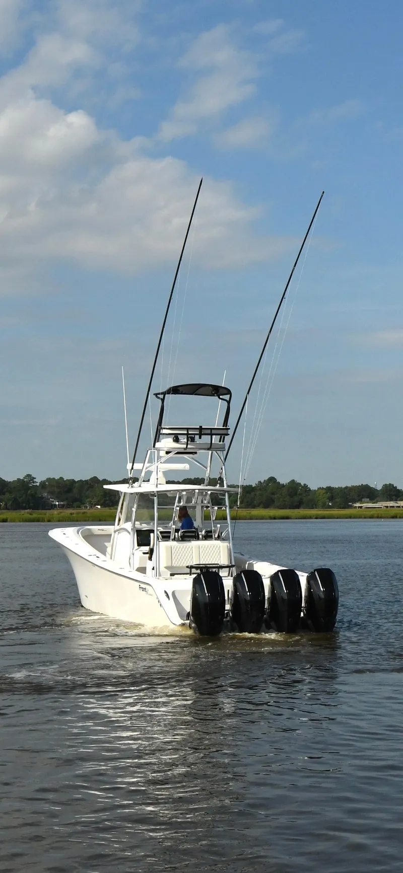 Slide: The Image of 2022 Front Runner 39 Center Console boat with four engines on a calm waterway. - 6