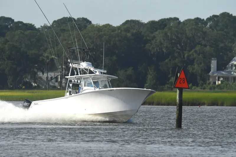 Slide: The Image of 2022 Front Runner 39 Center Console boat speeding on a river near a channel marker. - 7