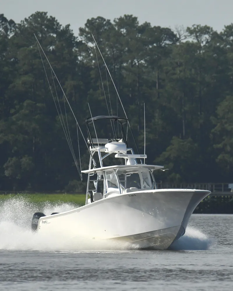 Slide: The Image of 2022 Front Runner 39 Center Console boat cruising on water with forest background. - 8